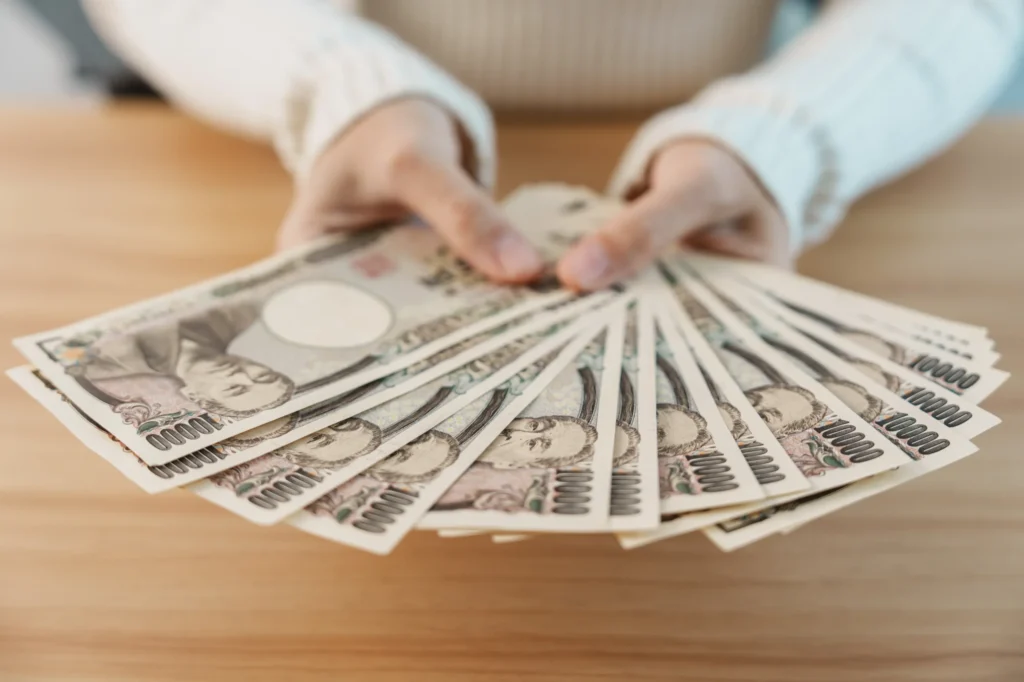 お金を広げて見せる
